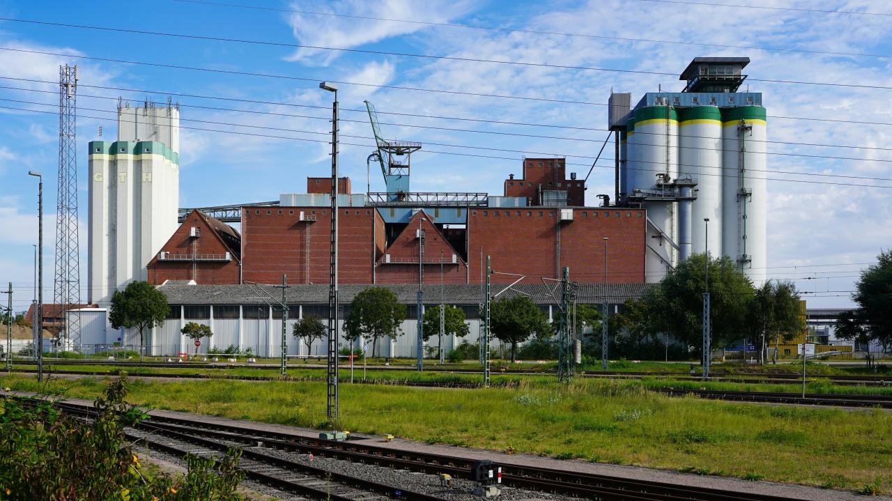 Kompleks industri dengan silo dan bangunan di bawah langit biru